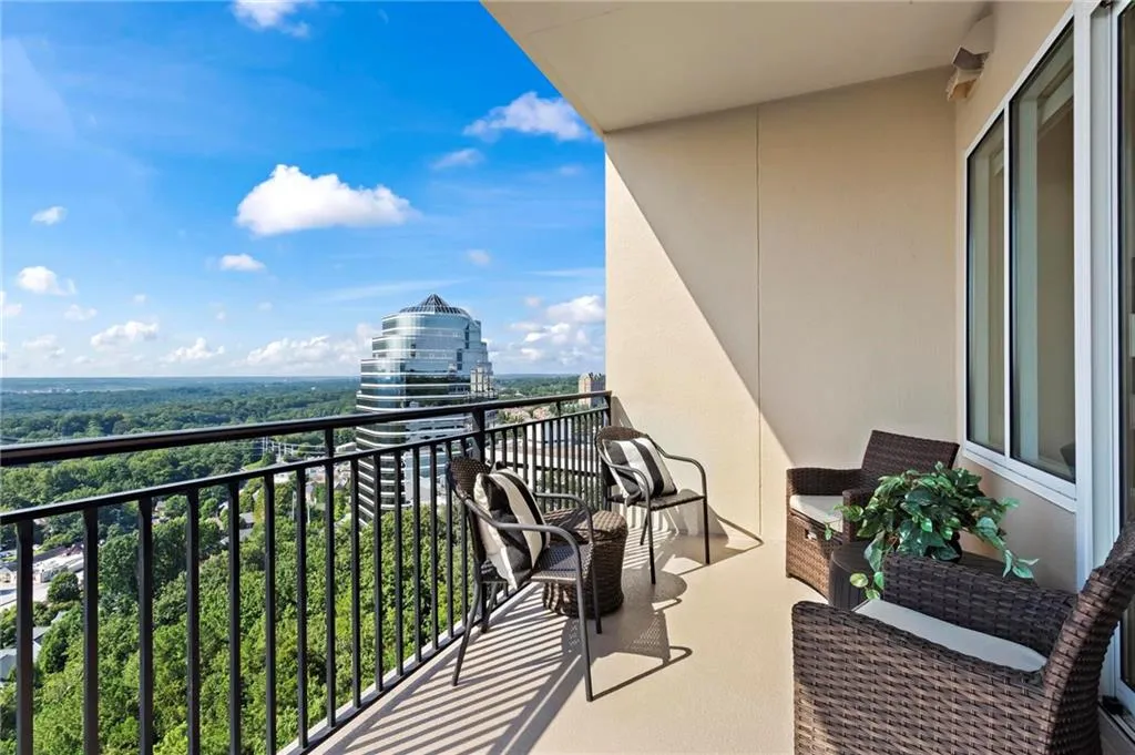 Spacious balcony featuring a black metal railing, painted concrete flooring, and an expansive skyline