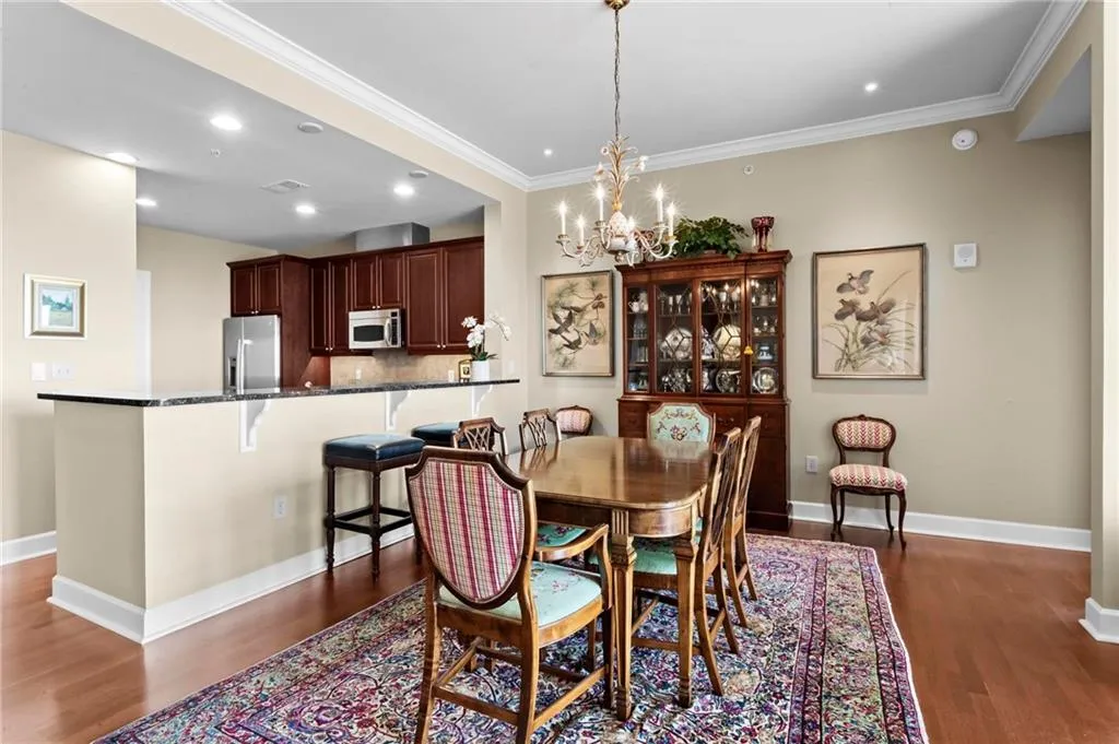 Open-concept dining area featuring wood flooring and a decorative chandelier