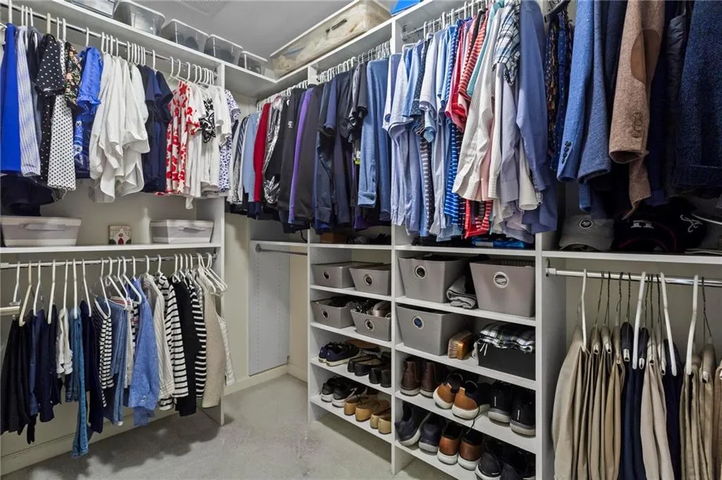 Custom closet system featuring multiple hanging rods, integrated shelving, and dedicated shoe storage