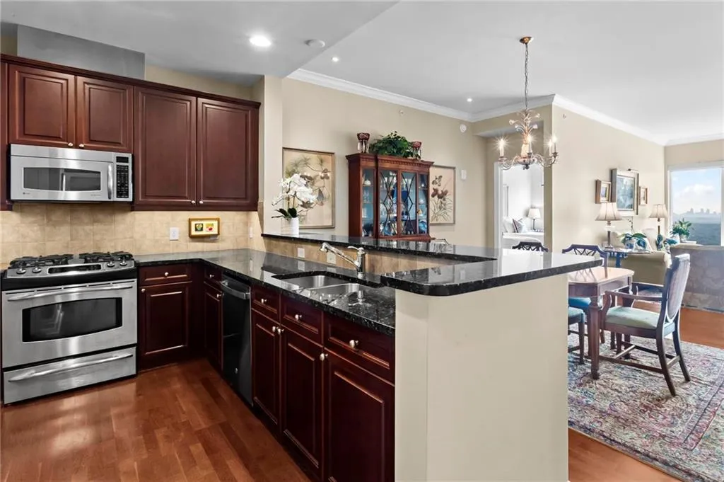 Kitchen featuring stained wood cabinetry, stainless steel appliances, a tile backsplash, and a breakfast bar