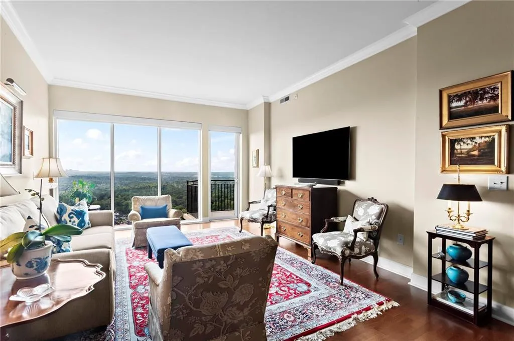 Unit 812 -  Hardwood flooring, crown molding, and expansive windows with a glass door to a balcony