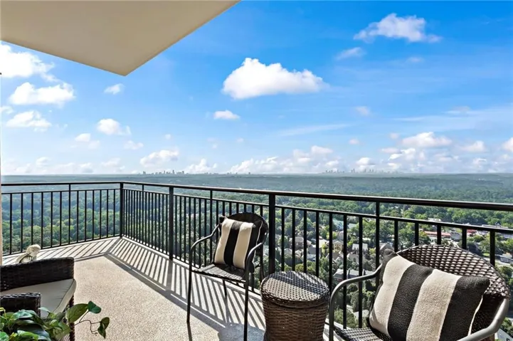 Exterior balcony with a black metal railing and concrete flooring, featuring an exceptional view