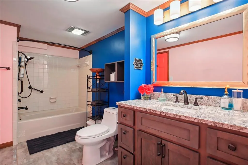Full bathroom featuring toilet, crown molding, tile flooring, tiled shower / bath, and vanity