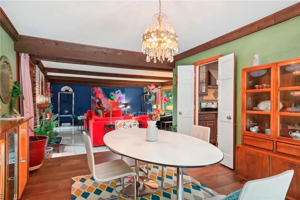 Dining area with beam ceiling, hardwood / wood-style flooring, and an inviting chandelier