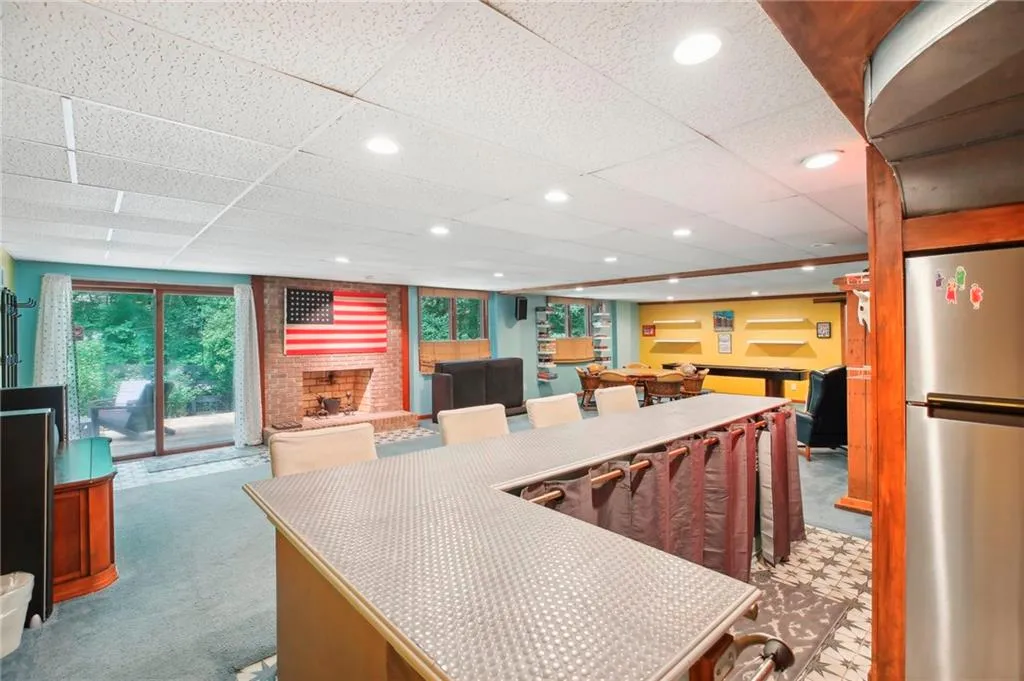 Kitchen featuring stainless steel refrigerator, a paneled ceiling, and carpet