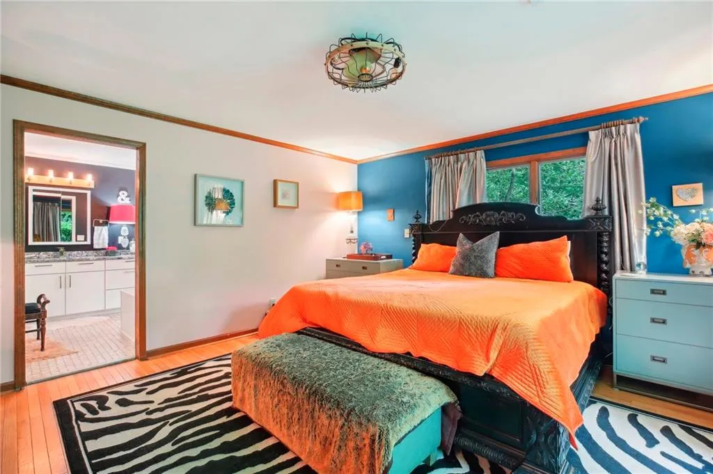 Bedroom with crown molding, ensuite bathroom, and light wood-type flooring