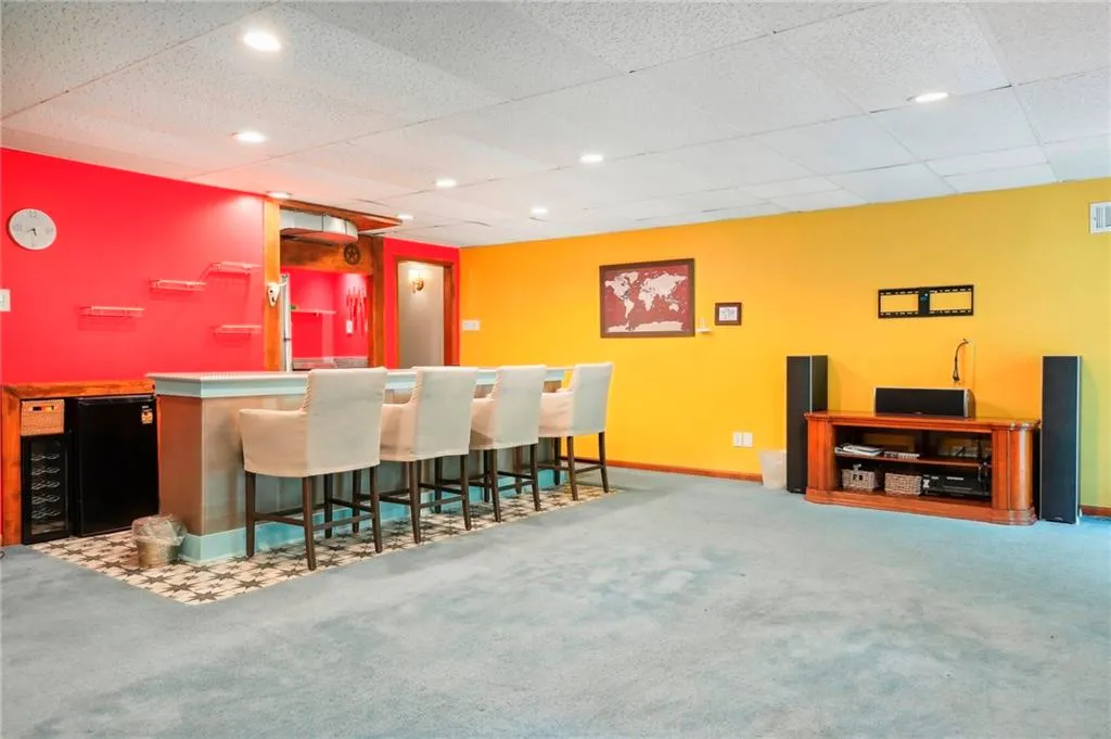 Bar with carpet floors and a paneled ceiling