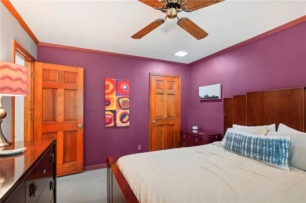 Carpeted bedroom featuring ceiling fan