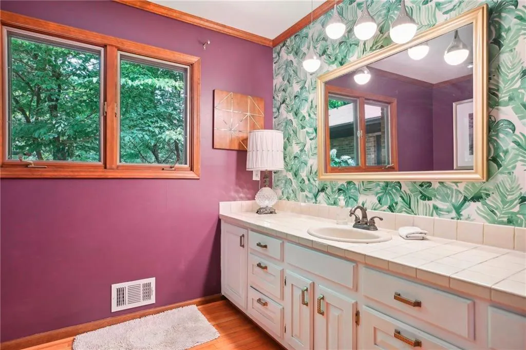 Bathroom featuring vanity, hardwood / wood-style flooring, and ornamental molding