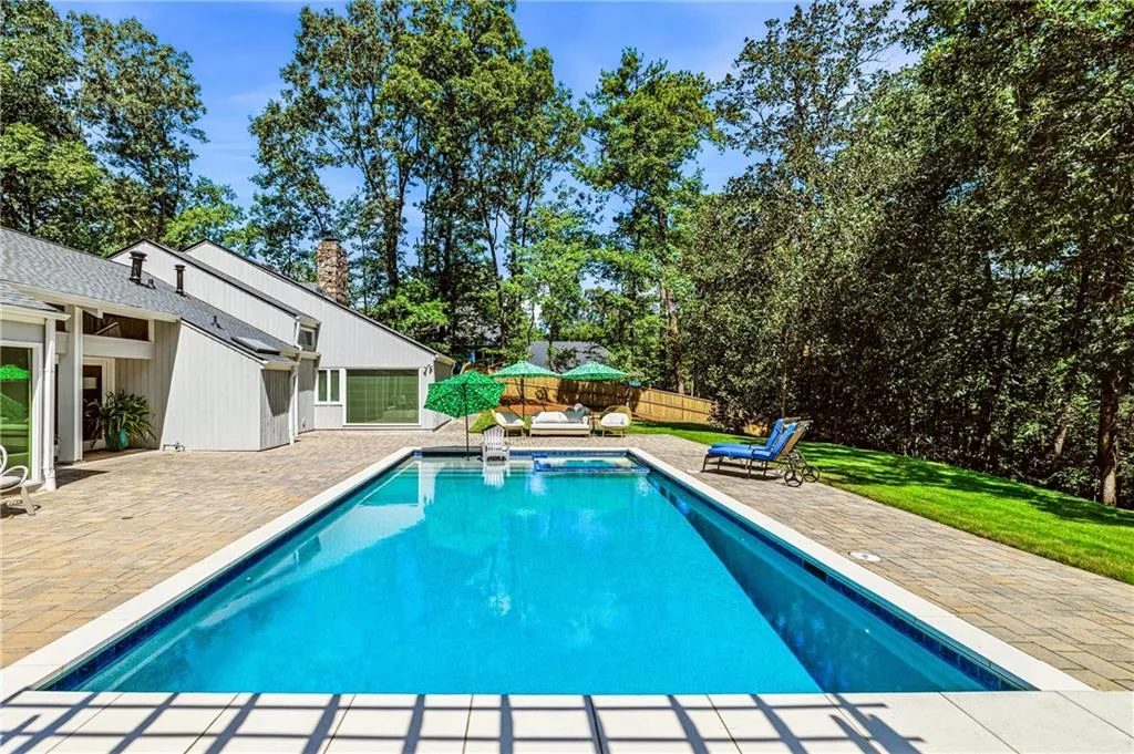 Rectangular in-ground swimming pool with a surrounding paver patio