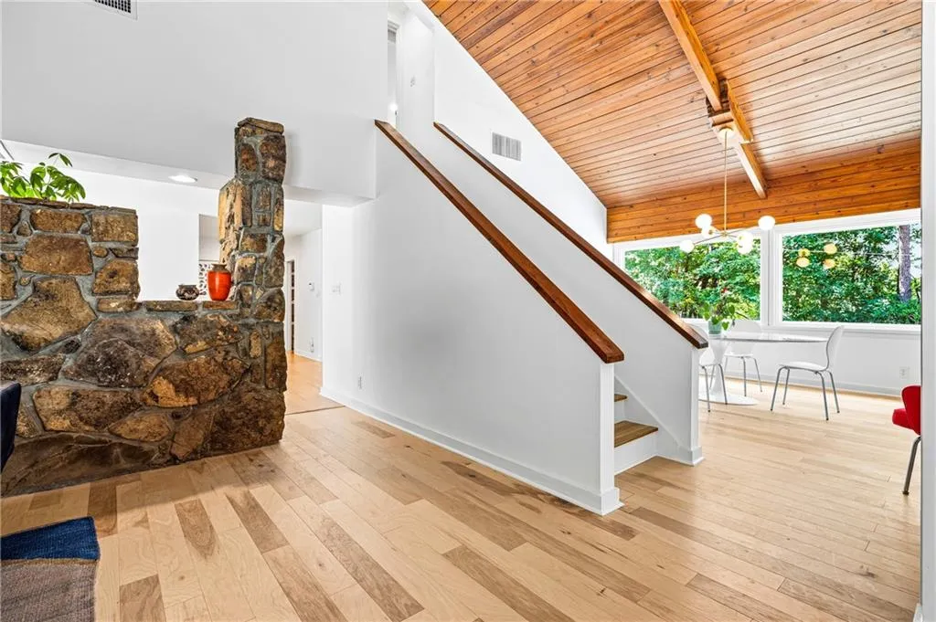 Den area looking into the dining room, walkway to kitchen and kitchen eating area, stairs to upstairs bedroom with full bathroom