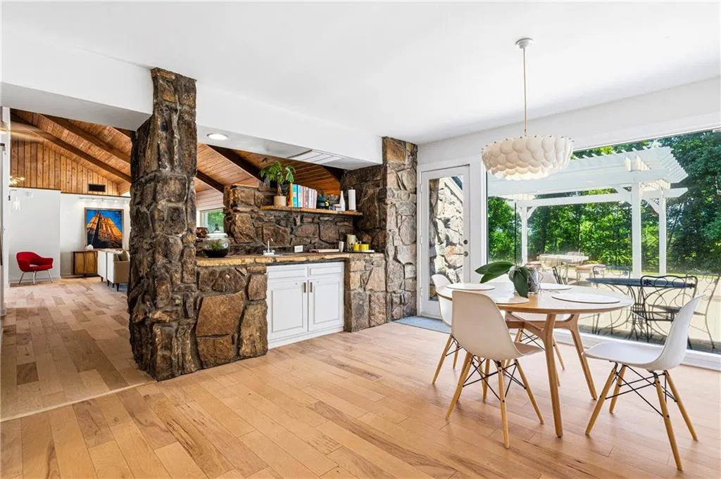 Kitchen eating area overlooking stone wet bar and backyard floor to ceiling views!