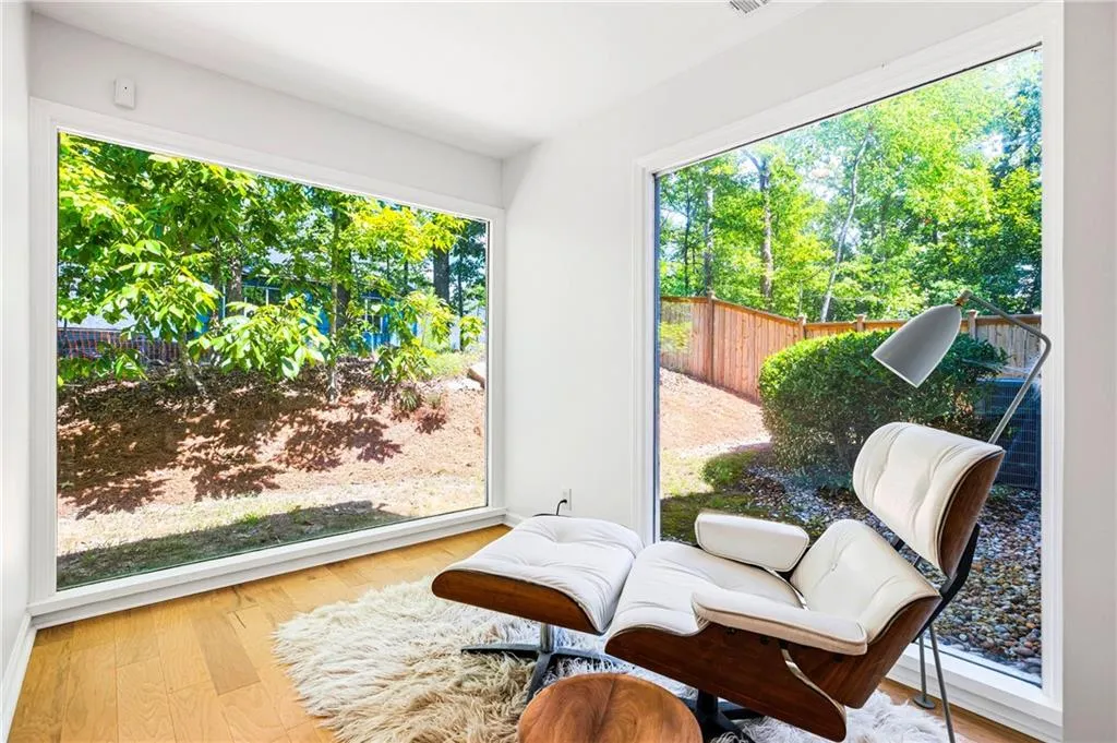 Room featuring expansive floor-to-ceiling windows, wood-finish flooring, and crisp white walls