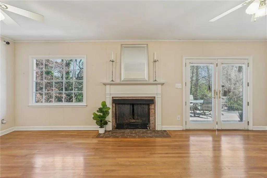 Family room with fireplace opens to patio and kitchen and includes hardwood floors, ceiling fans, crown moulding,and.