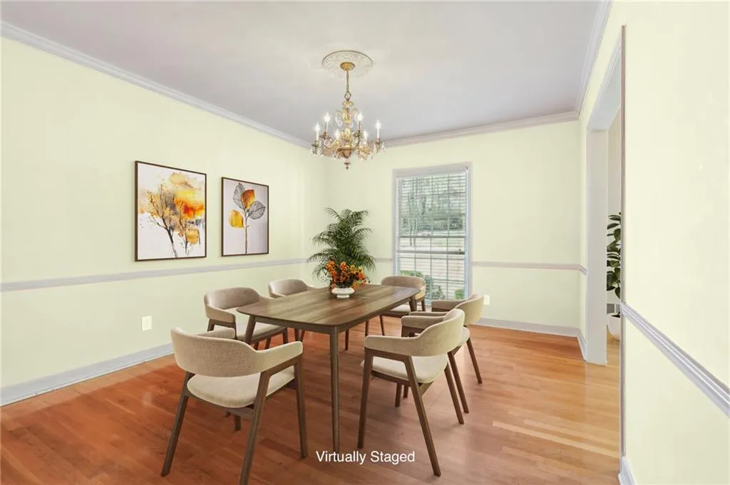 Dining room featuring hardwood flooring, chandelier, and crown molding - VIRTUALLY Staged (Paint & Furniture)