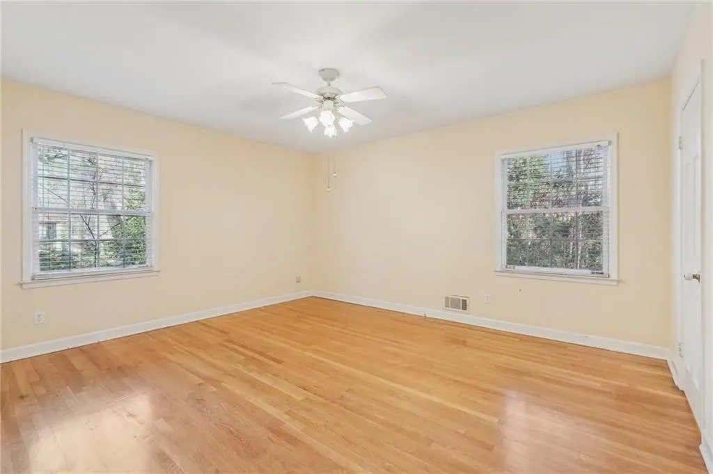 Primary Bedroom features ELFA closet shelving en-suite bathroom, hardwood floors and ceiling fan.