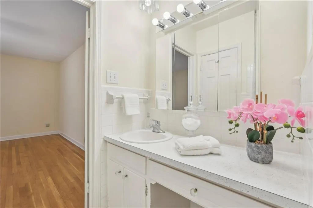 Bathroom with hardwood / wood-style flooring, decorative backsplash, and vanity