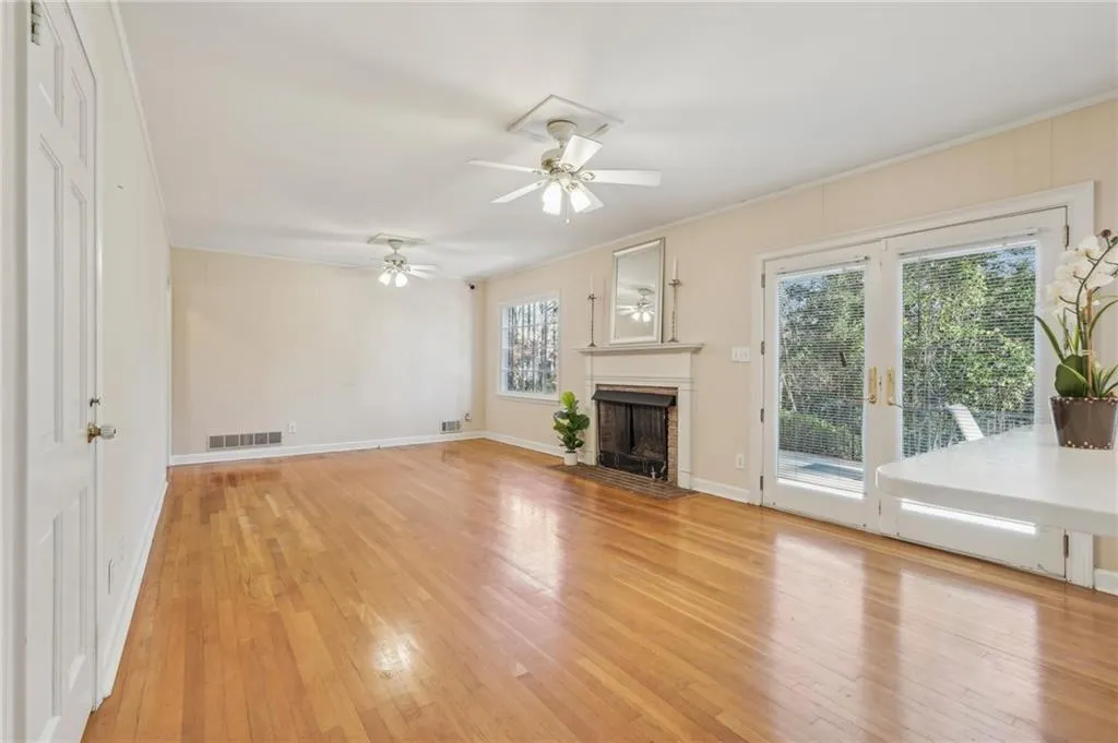 Family room opens to kitchen and patio and includes hardwood floors, ceiling fans, crown moulding, and fireplace.