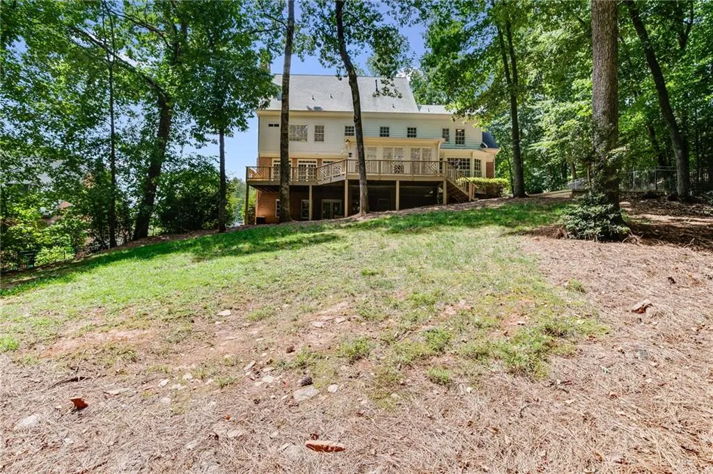 Rear view of house featuring a deck and a lawn
