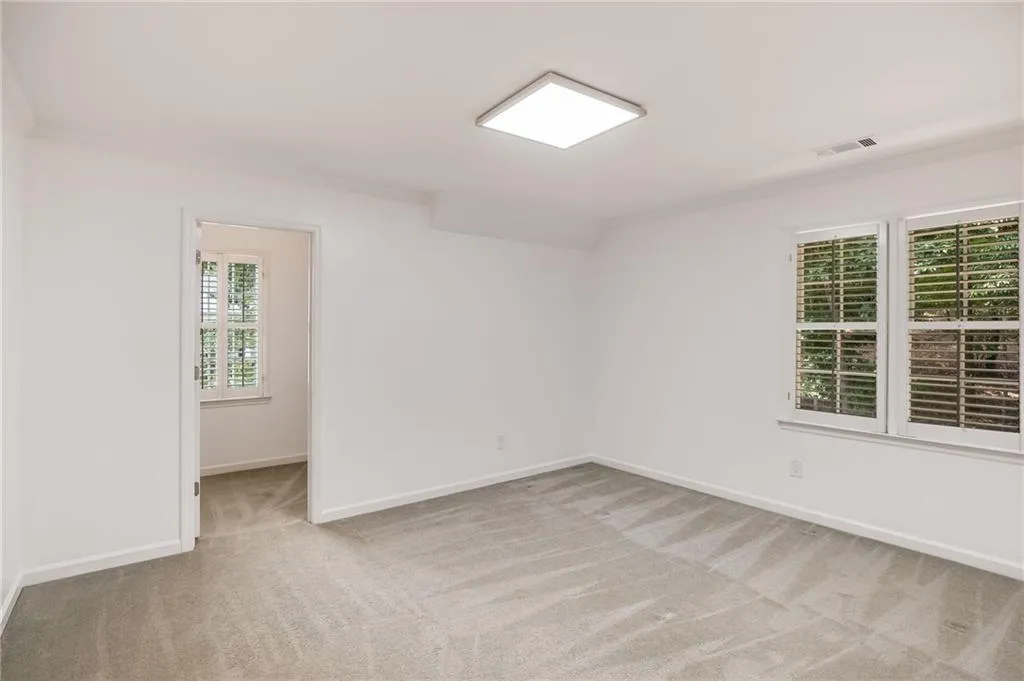 Empty room with light colored carpet and ornamental molding