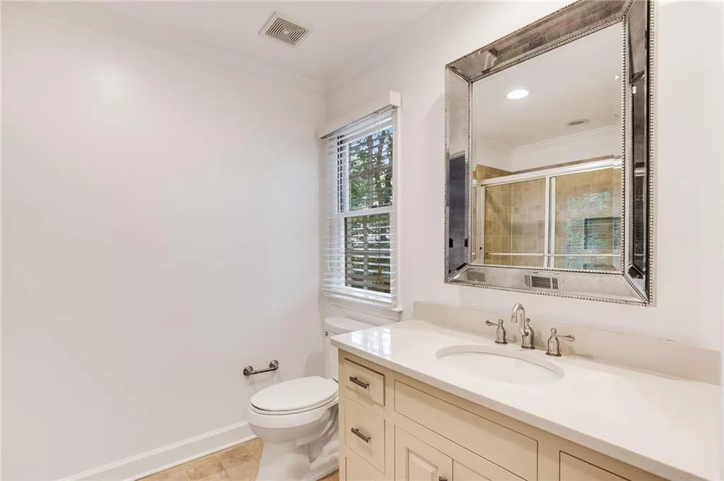 Full bathroom featuring ornamental molding, vanity, a stall shower, and light tile patterned floors