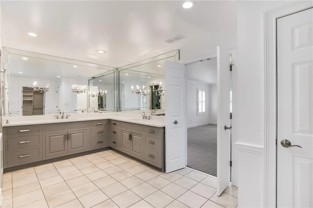 Full bath featuring a chandelier, light tile patterned flooring, double vanity, recessed lighting, and a closet