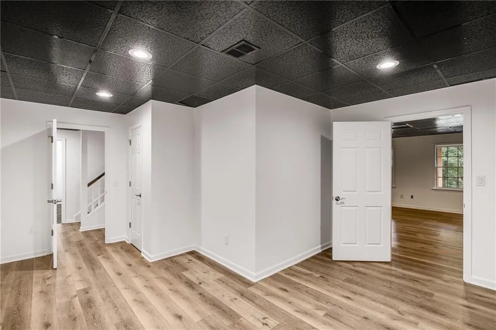 Empty room featuring a drop ceiling and light wood-style floors