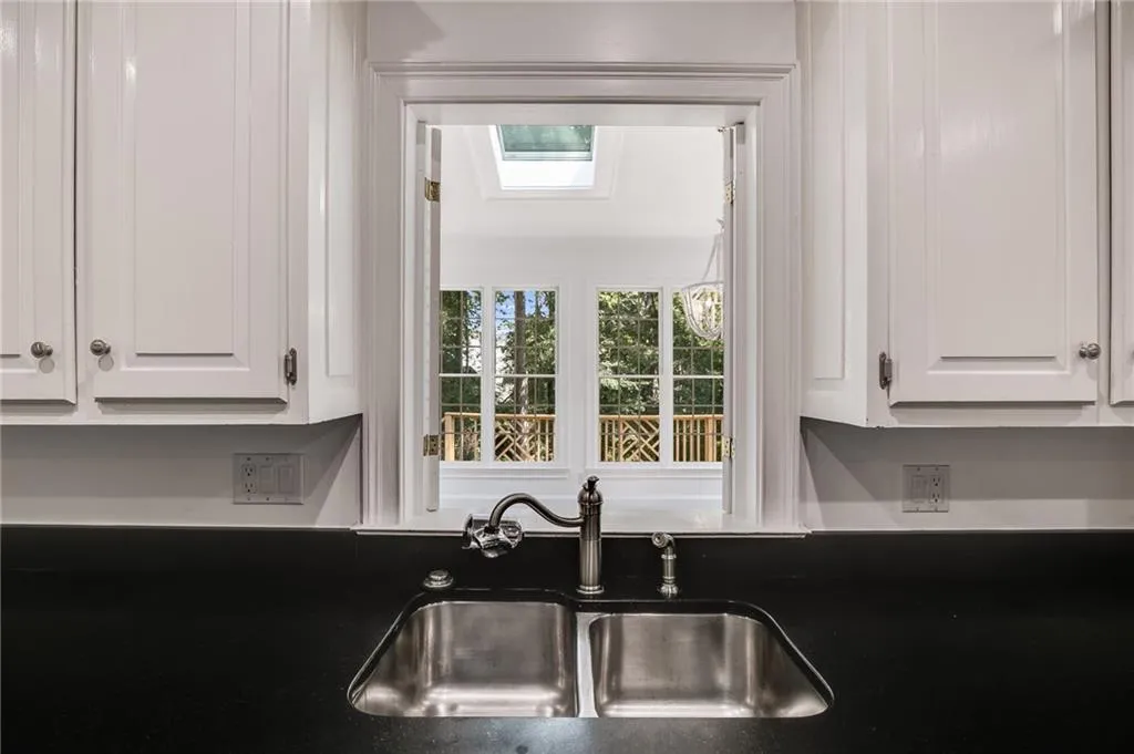 Kitchen with white cabinetry and dark stone counters