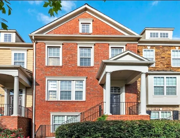 Brick facade with a gabled roofline, dormer window, and white-trimmed windows