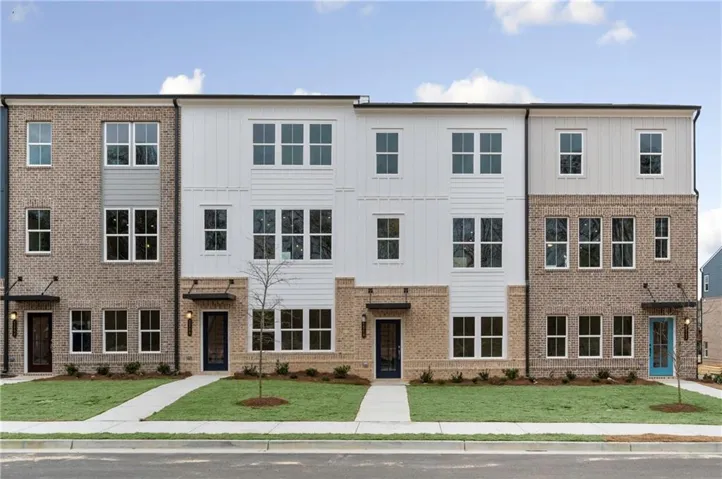 Townhome / multi-family property featuring a front lawn