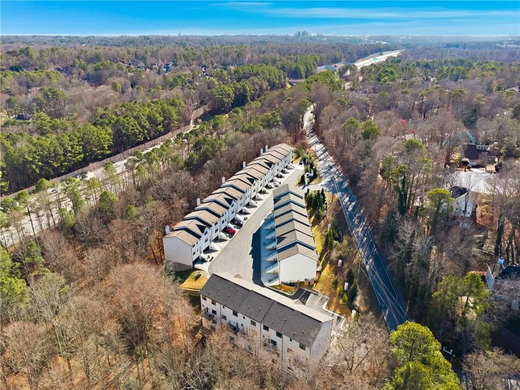 Aerial view of property's location with a heavily wooded area