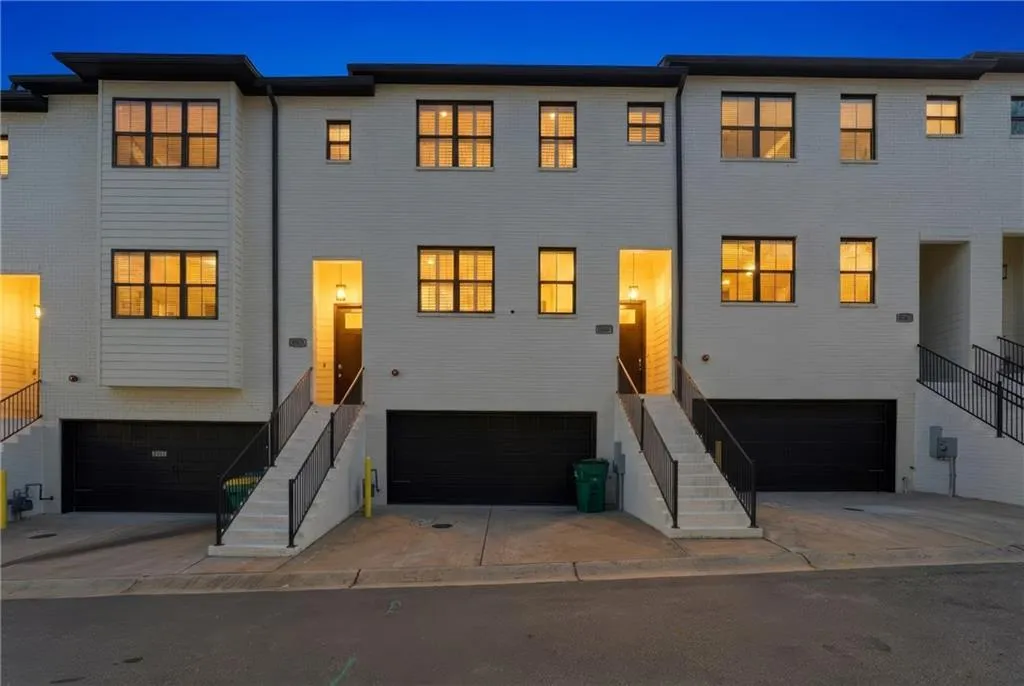 View of front facade featuring an attached garage, brick siding, and concrete driveway