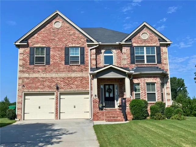 Brick exterior with a gabled roofline, covered front entry, and two-car garage with carriage-style doors
