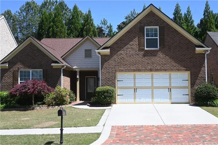 View of front facade featuring a garage and a front yard