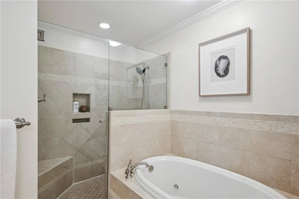 Full bathroom with a tub with jets, tiled shower, and crown molding