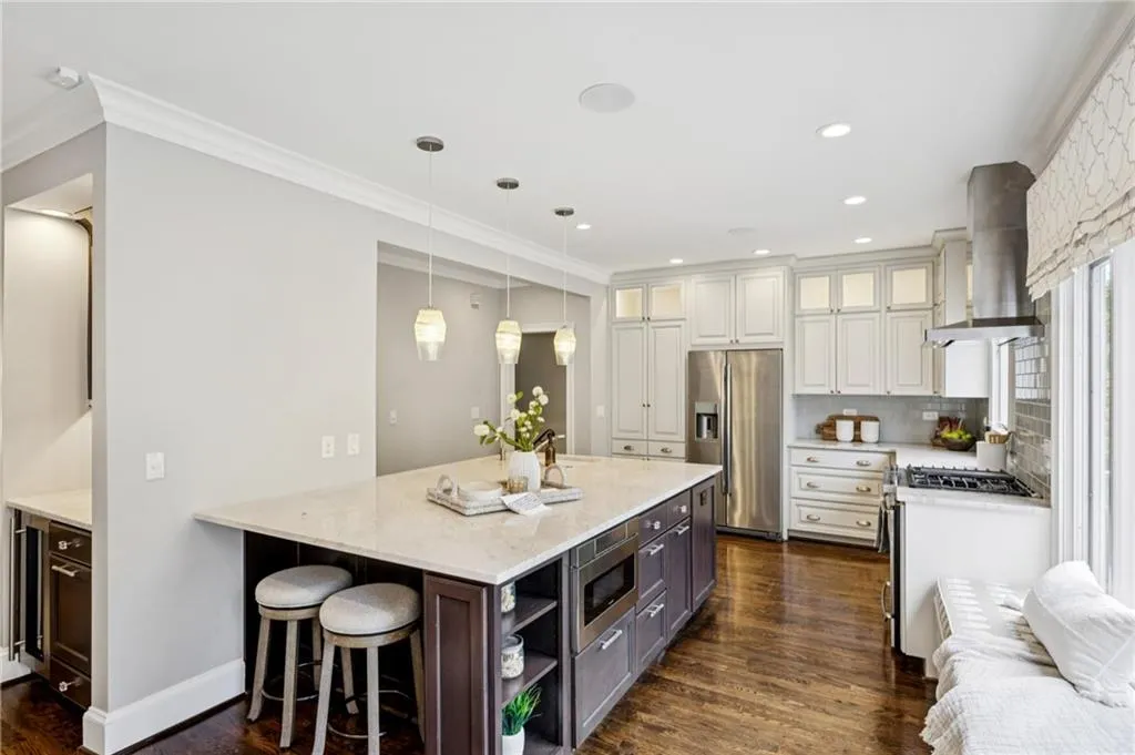 Kitchen featuring a kitchen bar, open shelves, dark wood finished floors, stainless steel appliances, and pendant lighting