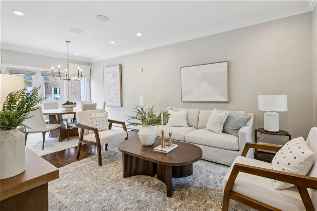 Living area with ornamental molding, wood finished floors, a chandelier, and recessed lighting