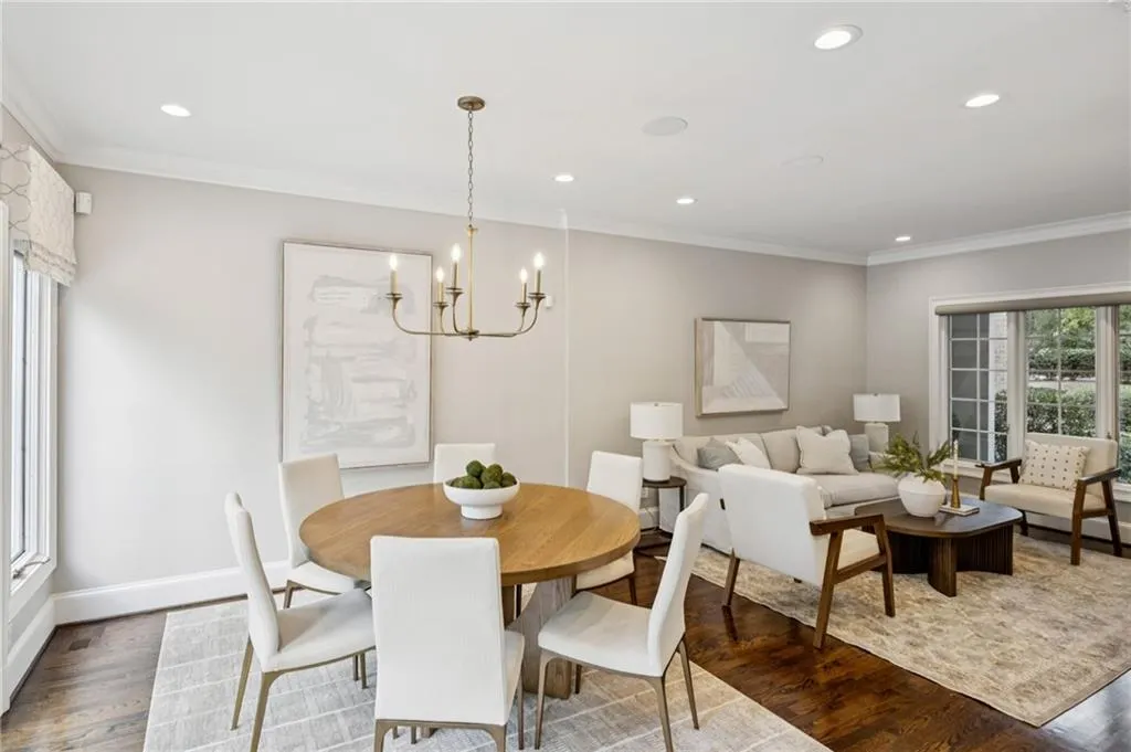 Dining area with ornamental molding, wood finished floors, recessed lighting, and a chandelier