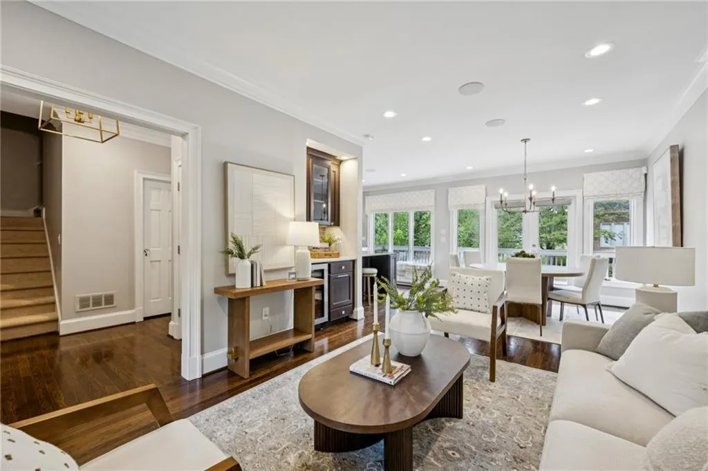 Living area with a chandelier, ornamental molding, dark wood finished floors, stairway, and recessed lighting