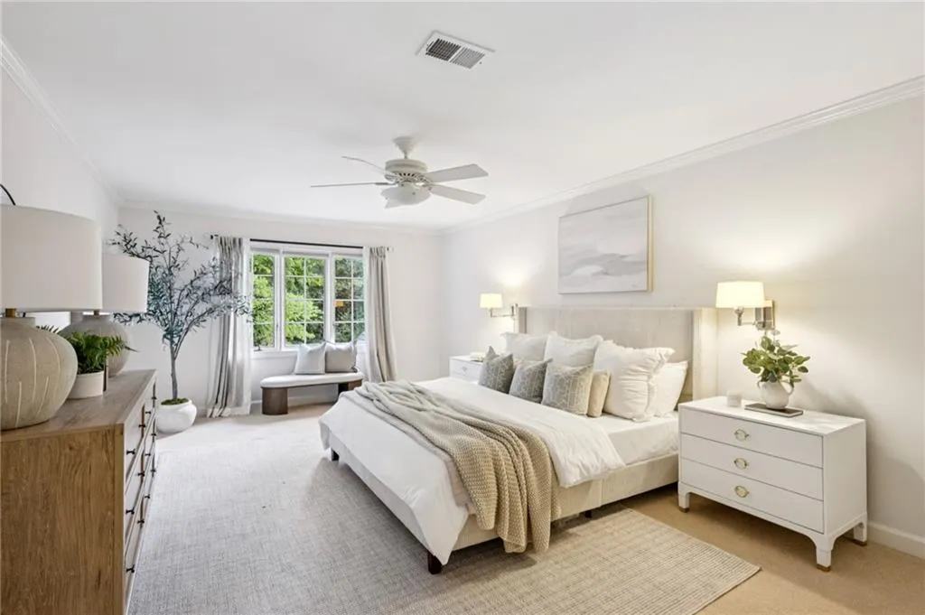 Carpeted bedroom with crown molding and a ceiling fan