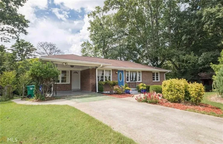 Brick ranch-style residence featuring a covered front porch, a blue oval-paneled entry door, and white-framed windows