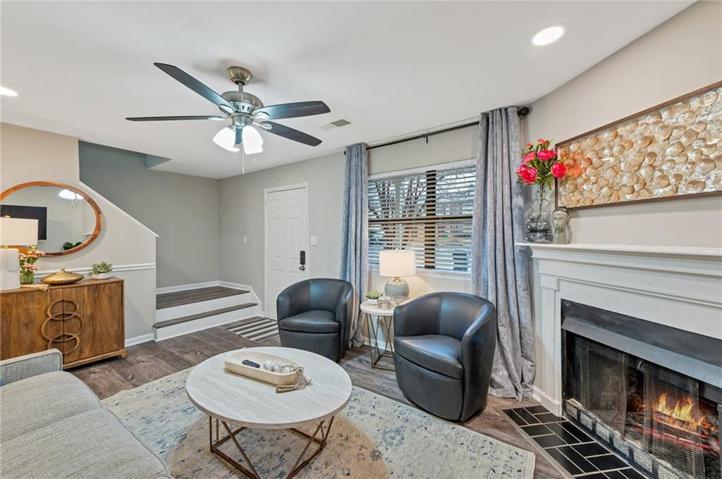 Living room with dark hardwood / wood-style flooring and ceiling fan