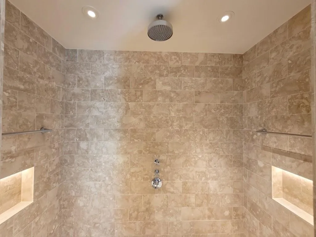 Tiled shower enclosure featuring a ceiling-mounted rainfall showerhead, recessed lighting, and built-in illuminated niches, virtual LED lighting
