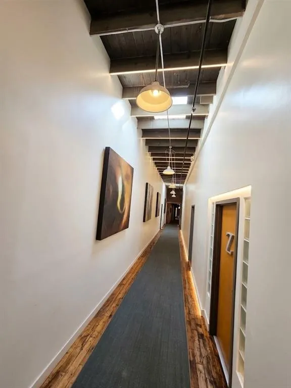 Exposed beam ceiling with skylights, wood-finish flooring, recessed lighting, and suspended pendant lighting