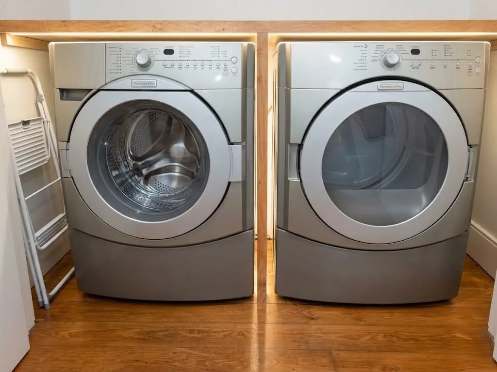 Front-loading washer and dryer set, wood-finish flooring, and integrated overhead lighting