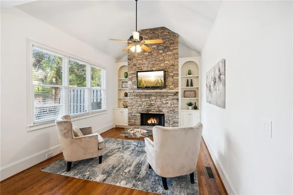 Keeping room with stacked stone fireplace and built-ins