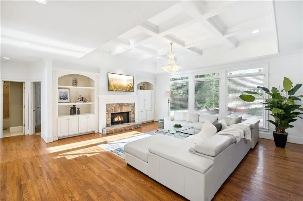 Living room with built in features, a fireplace, coffered ceiling