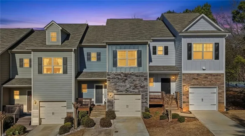 Craftsman house featuring board and batten siding, stone siding, driveway, and a garage