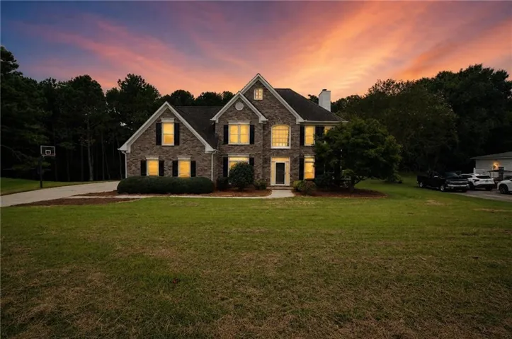 Brick exterior with multiple gables, an attached two-car garage, and a concrete driveway