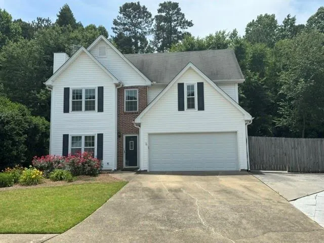 Two-story property featuring white siding and brick accents